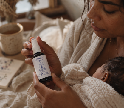 Postpartum mother holding Mother Moon Baby Blues herbal tincture
