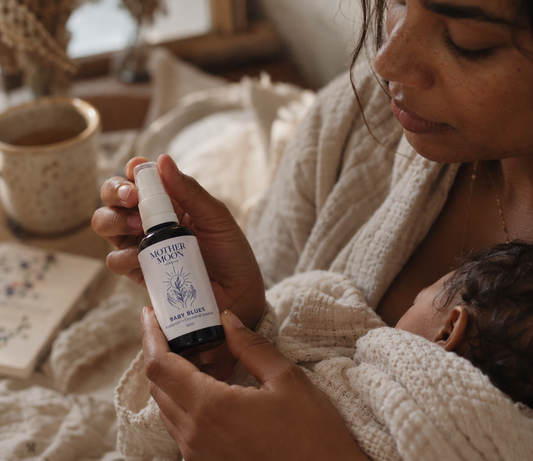 Postpartum mother holding Mother Moon Baby Blues herbal tincture - alternative view